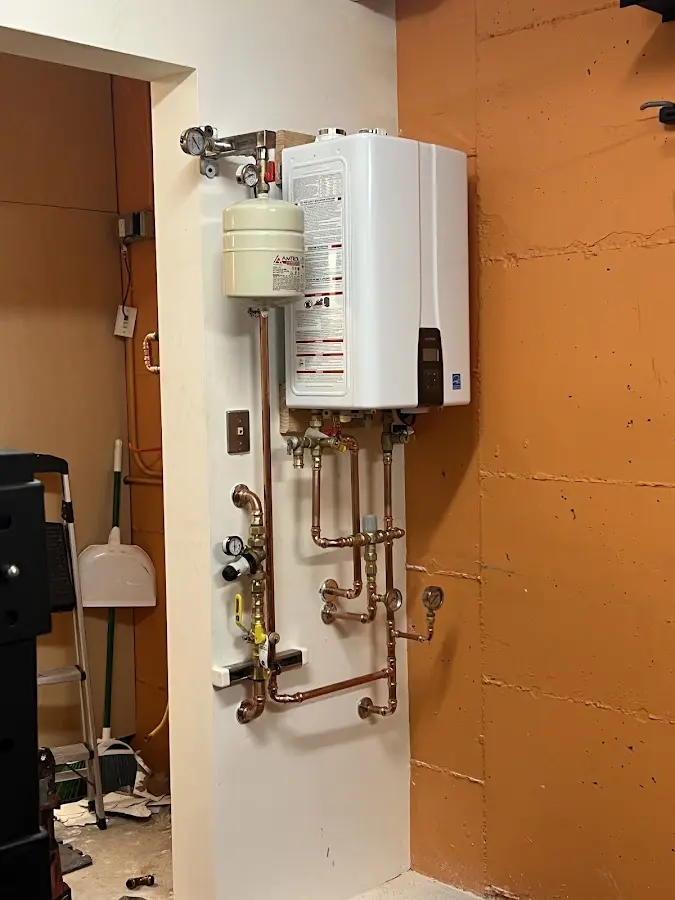 Plumbing technician inspecting water heater connections in Town and Country